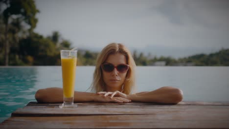 woman relaxing by the pool with a drink