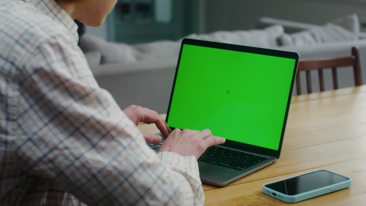 persona que trabaja en una computadora portátil con pantalla verde