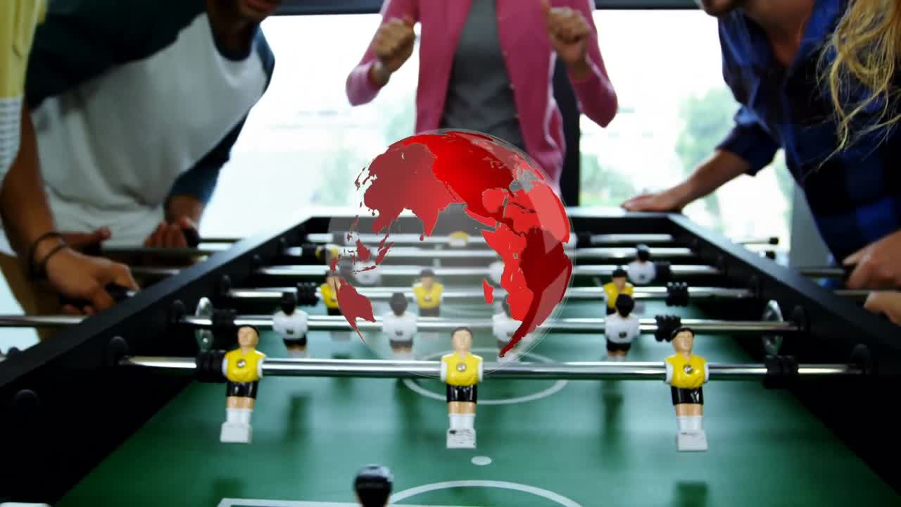 Animation of globe over diverse group of colleagues playing table football