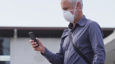 caucasian man out and about in the street wearing on a face mask against coronavirus