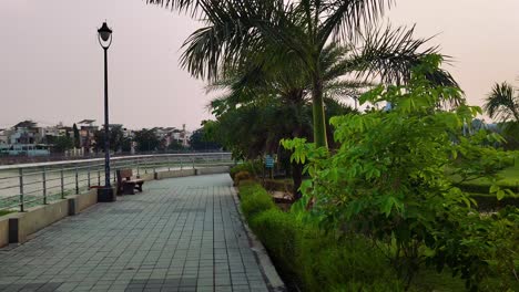 quiet garden path by lake with benches, trees and calm view. perfect peaceful nature scene for relaxation
