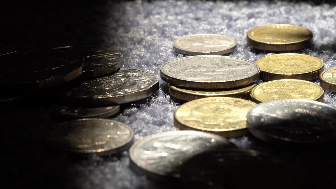 monedas australianas cayendo sobre la alfombra, un primerísimo plano en 4k