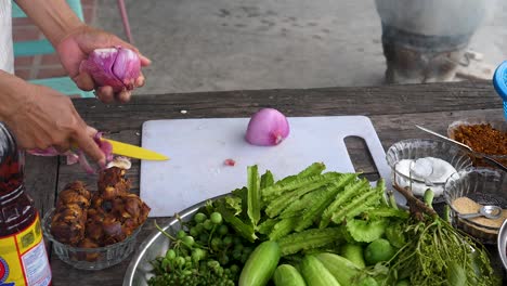 skinning red onion with knife, medium shot