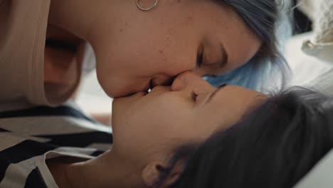 close up video of lesbian couple intimately kissing in bed.