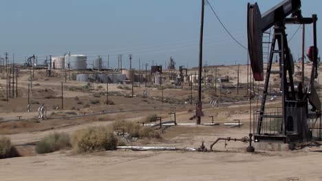 oil field with oil pump with oil pumps and tanks in california, usa