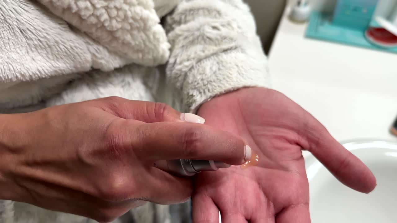primer plano de manos femeninas poniendo líquido facial en la mano, concepto de cosméticos para el cuidado de la piel