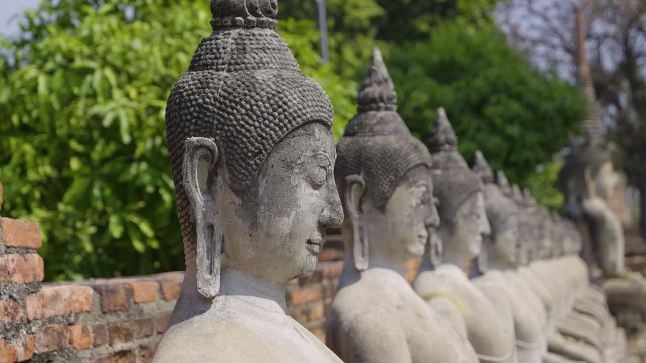 Slow cinematic close up of stone Buddha statues in Thailand