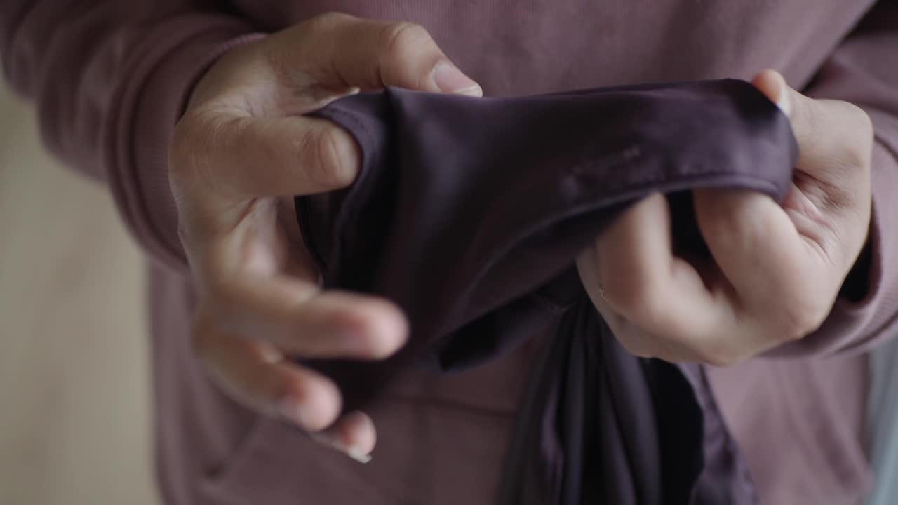 어두운 보라색 직물 한 조각 을 조사 하는 여자