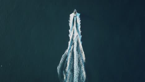 Amazing-aerial-view-of-person-water-skiing-in-calm-blue-turquoise-water---Fun-outdoor-activities---4k-drone-footage