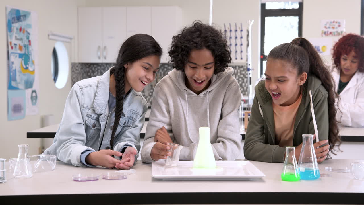 In school, multiracial students conducting science experiment with liquids, learning together