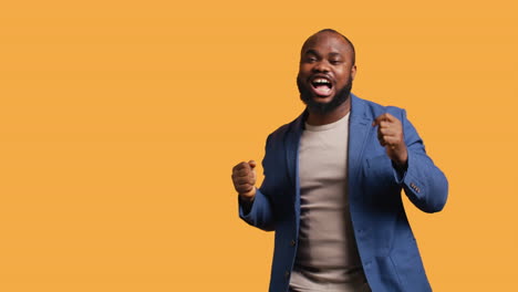 man dancing from happiness, celebrating achievement, studio background