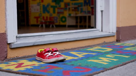 child's red shoes by preschool door
