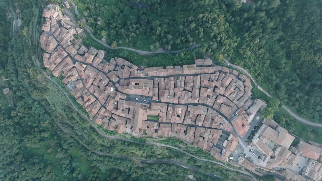 Top Down Aerial Drone view of the hilltop Medieval town of Pitigliano, Tuscany in morning light, with red tile roofs and old buildings, in 4K