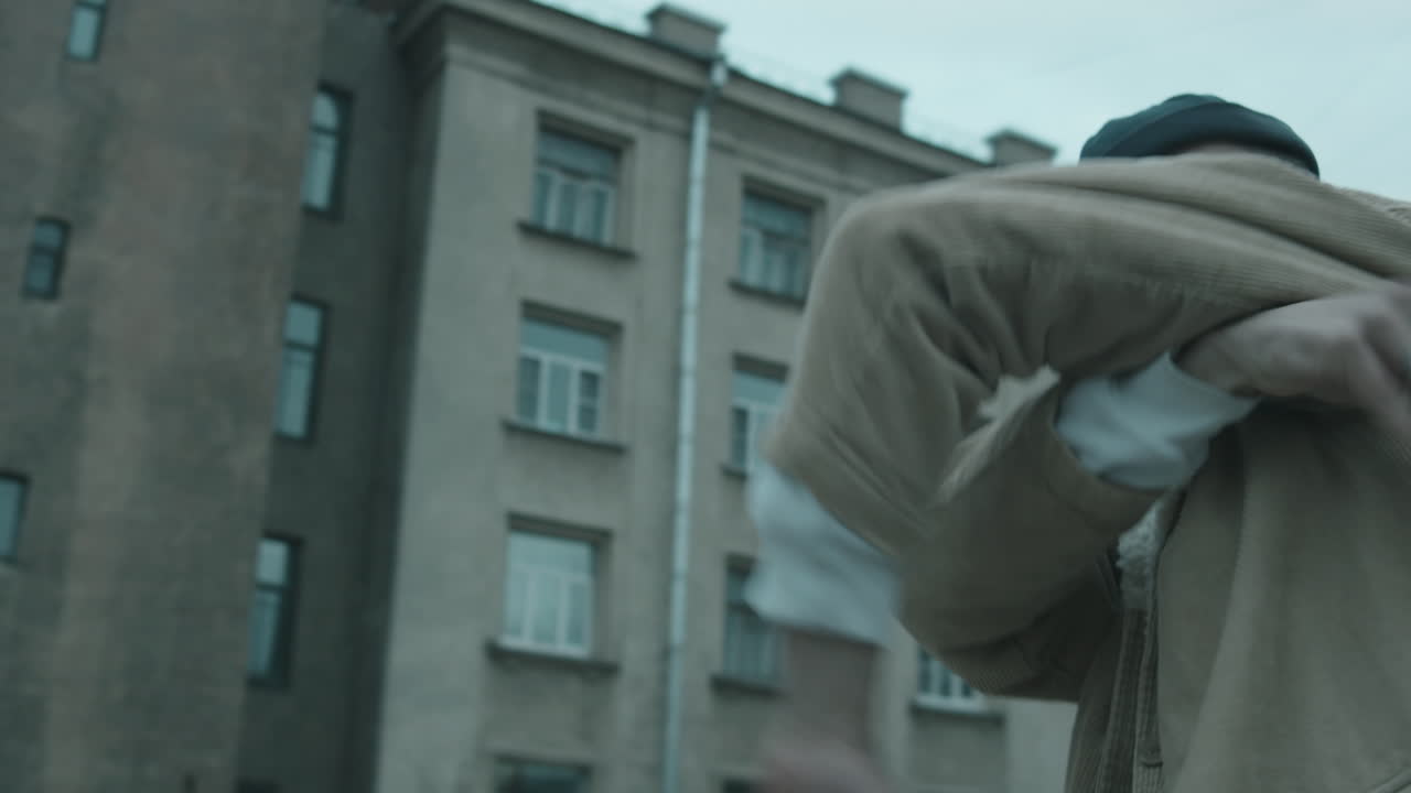 표현력 있는 남성 댄서 가 야외 에서 보그 를 공연 하고 있다