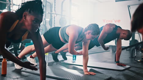 grupo diverso haciendo tablas en un gimnasio