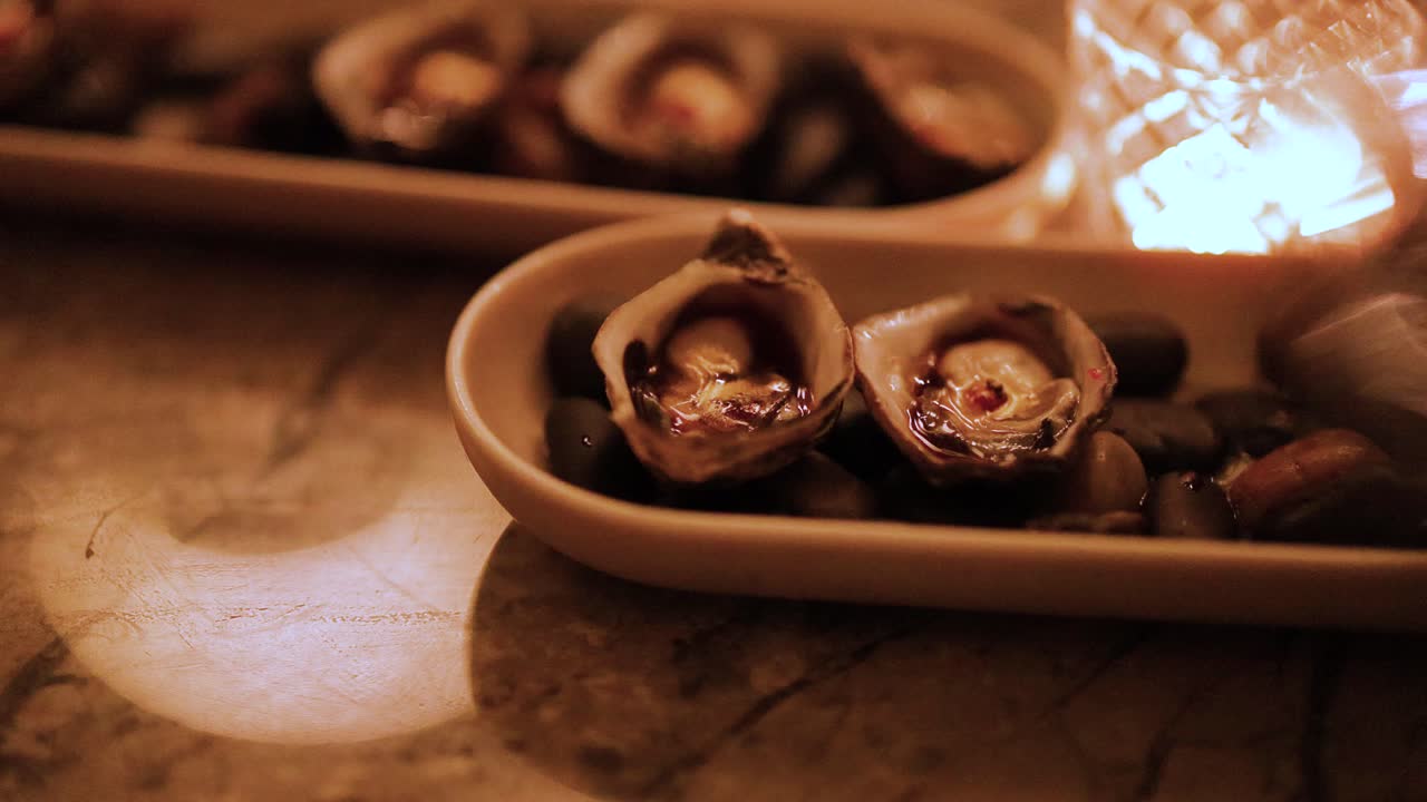 Close-up of oysters on a dish with warm, ambient lighting. Captured in Gold Coast, Australia, highlighting culinary elegance and inviting atmosphere