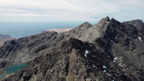 aerial drone shot of the cuillin mountains with a great view on the ocean in scotland