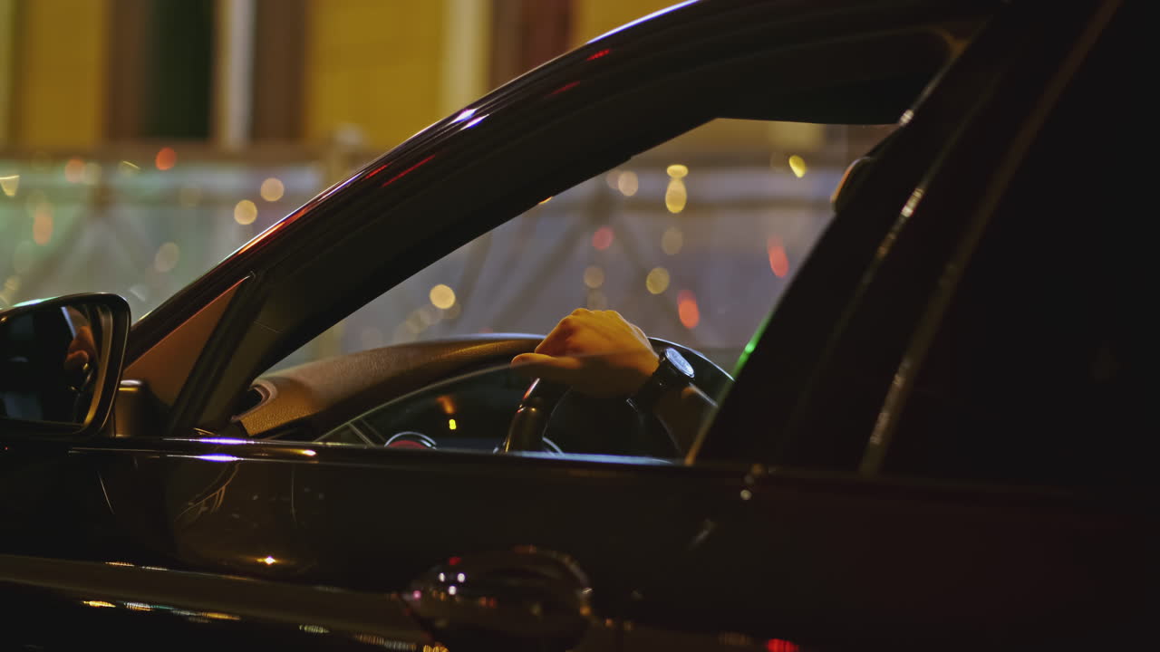 persona que conduce un coche de noche en la ciudad