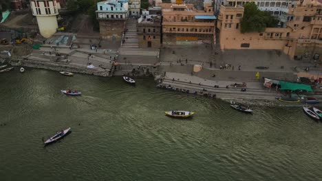 aerial view of banaras at sunrise, with the golden glow reflecting on the ganga river’s surface.