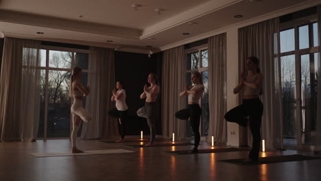 a group of women practice yoga under the strict guidance of an instructor in slow motion and sunlight at sunrise.