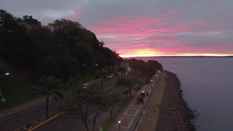 Imágenes-Aéreas-De-Una-Hermosa-Puesta-De-Sol-Desde-Una-Carretera-Costera-En-Posadas,-Misiones,-Argentina