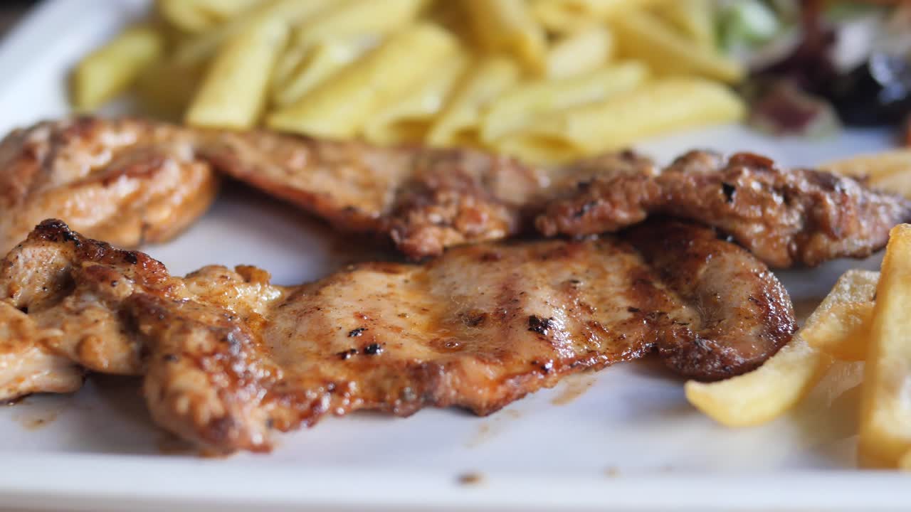 Pollo alla griglia con patatine fritte e insalata