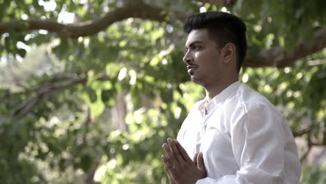 attractive asian man does yoga poses on the steps of a temple