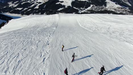 four snowboarders on an empty piste followed by a drone