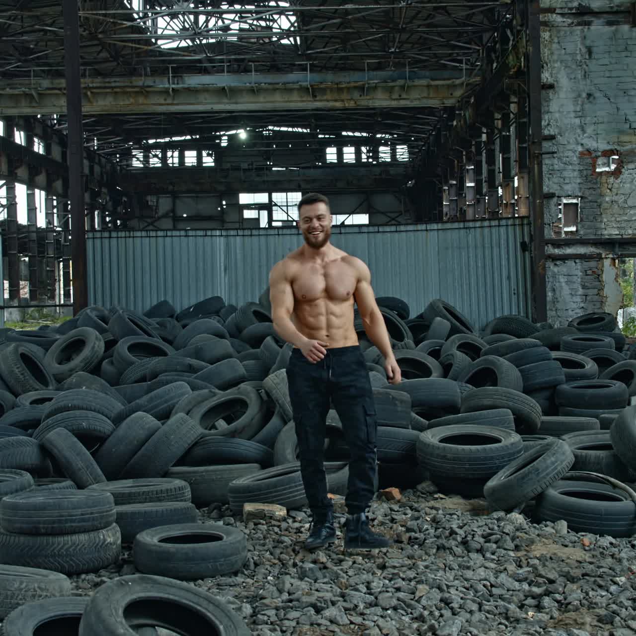Muscular man throwing tire