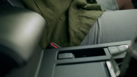 person fastening a car seatbelt