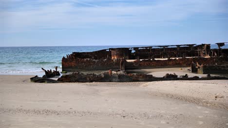 wide shot of the rusty s.s. maheno shipwreck on the beach