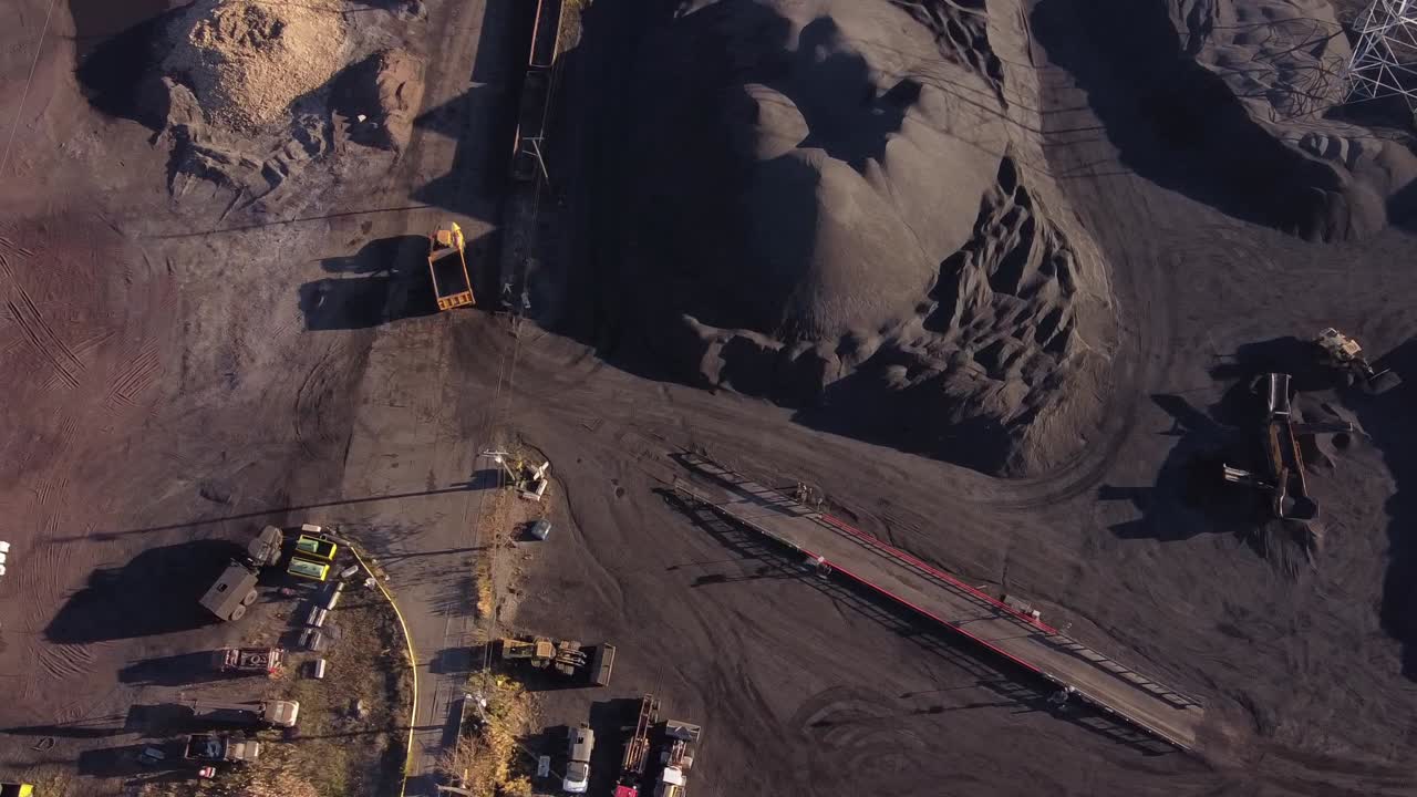 Dump Truck Driving Between Pile Of Petroleum Coke Storage At Zug Island In Detroit, Michigan, USA