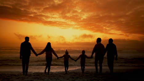 family silhouette at sunset beach