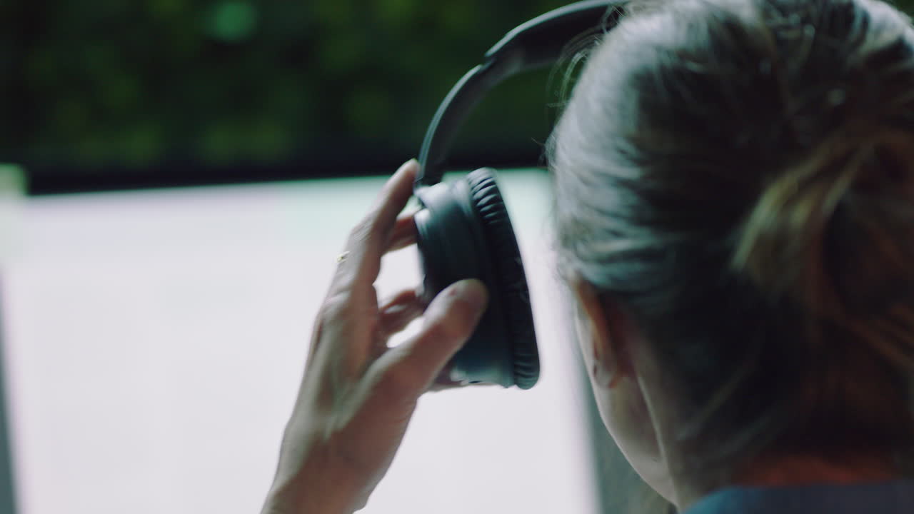 가까운 젊은 사업가 여성 컴퓨터를 사용하여 늦게 일하고 온라인 브라우징 계획 창의적인 스타트업 전략 음악을 듣고 밤에 사무실에서 헤드폰을 착용