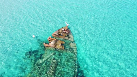 old rusty shipwreck in turquoise sea dron circle