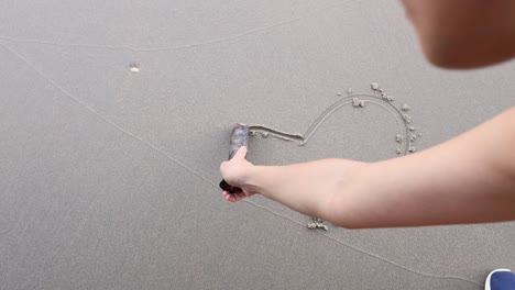 sequential drawing of a heart shape on beach