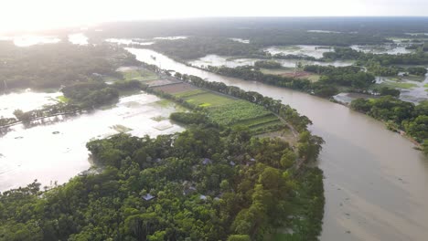 flooded fields beside river tributary in due to rising climate change with bright afternoon sun shining