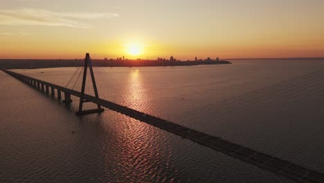 drone flying over the san roque gonzález de santa cruz international bridge at sunset