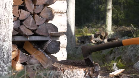 Man-prepares-Firewood,-Axe-Stuck-In-Tree-Stump-,-Slow-motion-Dolly-motion