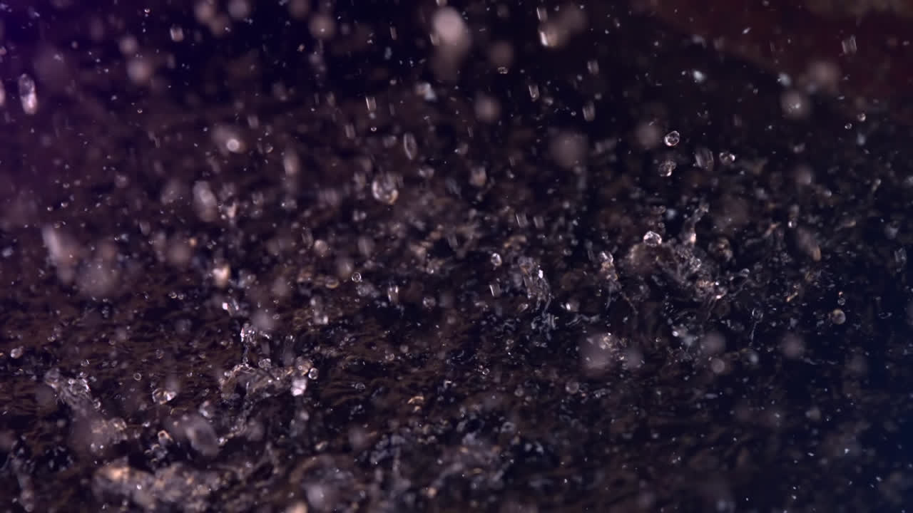 Animaatio vesipisaroista putoamassa mustalla taustalla.