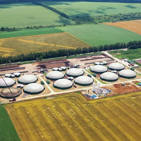 organic farm on field. biogas complex on agricultural lands background. view from above of storage tanks. energy production plant. aerial view