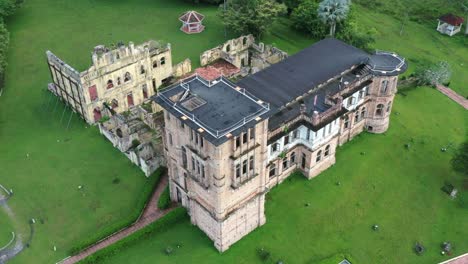 drone fly around historic moorish revival kellie's castle next to raya river, capturing exterior details of the mansion at batu gajah, kinta district, perak, malaysia