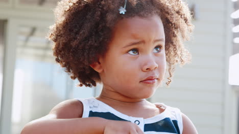 young black girl blowing bubbles outside her home
