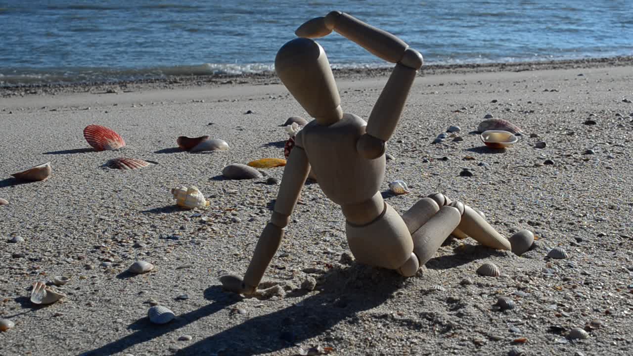 Dřevěná figurína na pláži. Focení na pláži.