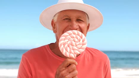 an elderly man eating a lollipops