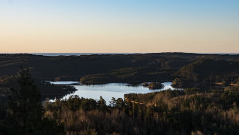 Light-and-shadows-move-over-Grimenes-Lake,-Norway-in-sunrise-time-lapse