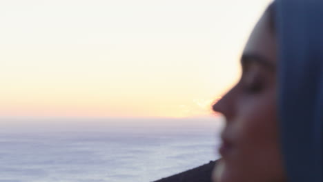 close up portrait of beautiful muslim woman looking contemplative exploring spirituality feeling peaceful enjoying sunset wearing hijab headscarf