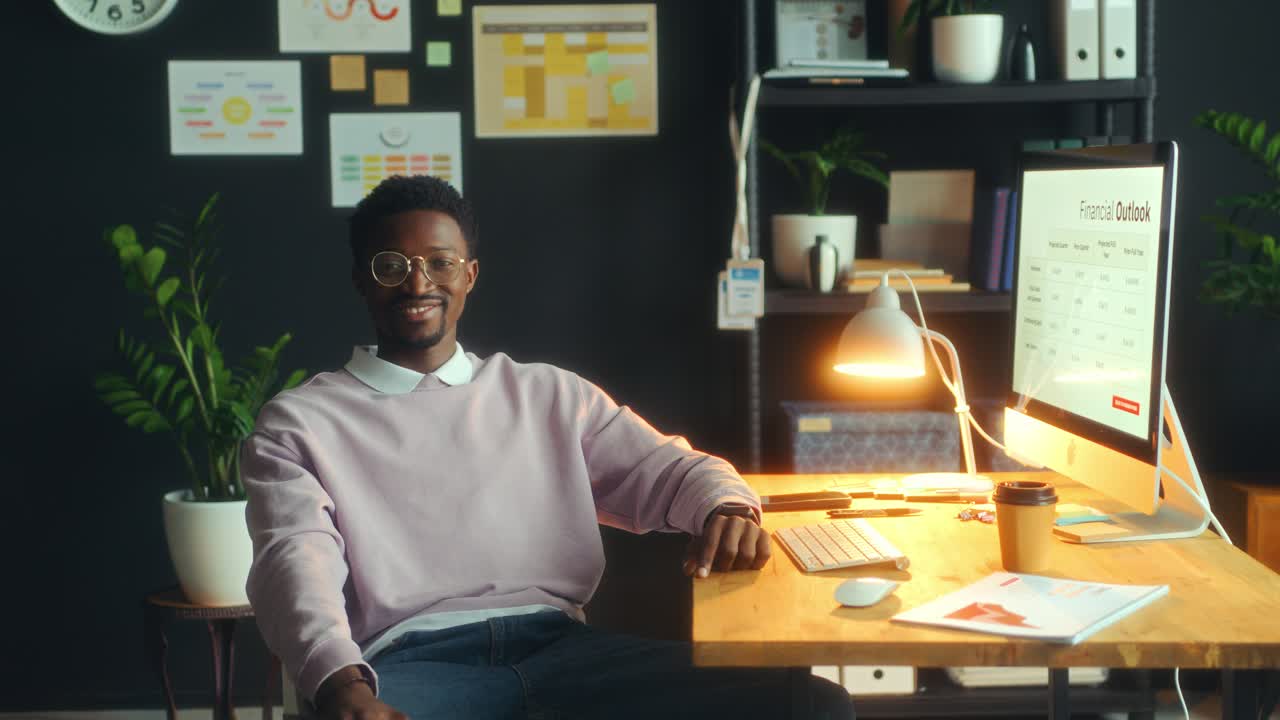Ritratto di un uomo afroamericano sorridente che lavora alla scrivania in ufficio