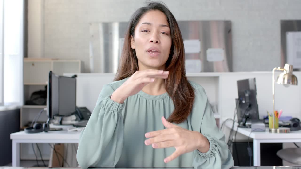 feliz mujer de negocios casual biracial haciendo una videollamada, hablando y saludando, cámara lenta