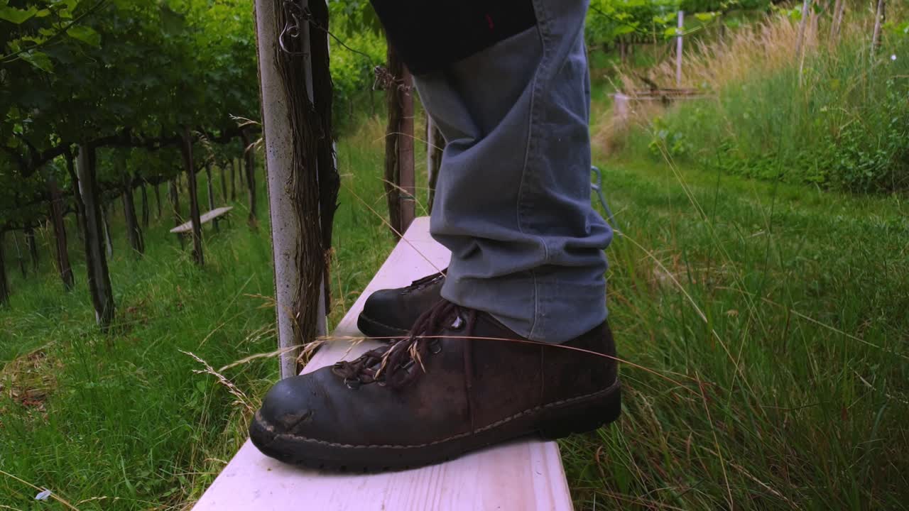 Following workers feet whilst stepping on a bench. Slow motion close up.